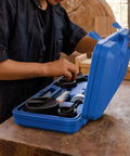 Person using Beefy 6 Ton Manual Knockout Hole Punch Kit with Ratchet Wrench and Six Die Set for electrical jobs in blue case