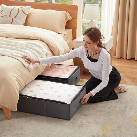 Woman placing comforter in 4 Pack Under Bed Storage Containers 95L Large Capacity With Reinforced Handles For Blankets, Grey