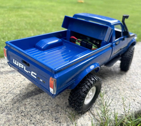 RC Crawler C24 4x4 Off Road Truck RTR 1/16 Scale shown in blue with open truck bed on grass, featuring realistic details.