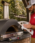 Person using Heavy Duty Cleaning Wipes For Paint Prep And Degreasing, Flat Pack Travel Size Towels For Hands And Tools, Eco Friendly And Unscented, Ideal DIY Garage And Job Site Cleanup on pizza oven tool outdoors.