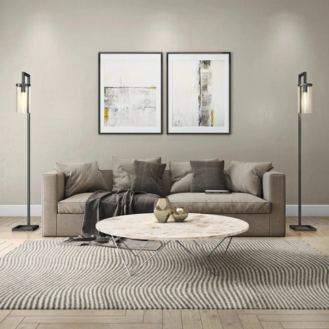 Living room with 67 Inch Tall Floor Lamp With Clear Glass Cylinder Shade In Polished Nickel Finish on each side of the sofa.
