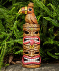 Outdoor Tiki Statue Decoration Solar Garden Figurine With Woodpecker On Top, 15 inch tall against green foliage