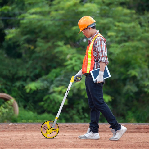 Heavy Duty Gear Driven Measuring Wheel With Tough Plastic Housing And Five Digit Counter Built Like A Tank With Quick Fold Handle And Kickstand Diecast Aluminum Wheel Aces Road Layouts Mw40M in use by a worker outdoors.