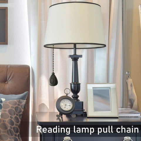 Four Pack 12 Inch Ceiling Fan Pull Chain Extenders in Black Copper Finish hanging from a reading lamp.