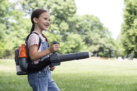 Child playing with 150BT Inspired Toy Bubble Leaf Blower, featuring air blast and lights, outdoors on a sunny day.