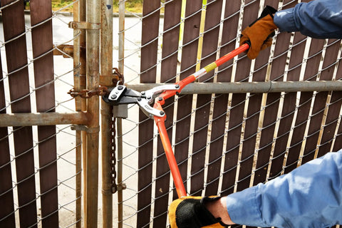 Person using PowerPivot Center Cut Double Action Bolt Cutter Beast, 36-Inch Heavy Duty Tool on metal chain.
