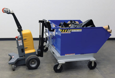 Heavy Duty Electric Powered Tugger With 1000 Lb Pull Capacity For Effortless Factory Material Handling Featuring Ergonomic Handle And Dead Man Switch Safety System In Bright Yellow Black Finish next to blue container.