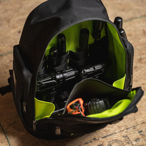Open black rugged extreme tool backpack with green interior and multiple tool pouches including a flashlight and power drill.