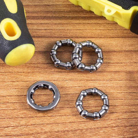 Close-up of Four Pack 0.2 Inch Ball Bicycle Bearing Set For Crank Bottom Bracket Axle Replacement on wooden surface with tool.