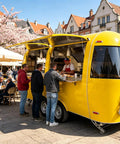 Top Tier Stainless Steel Food Trailer A Solid 16 Foot Yellow Mobile Kitchen Built Tough And Dot Certified For Street Ready Operators at a busy market.