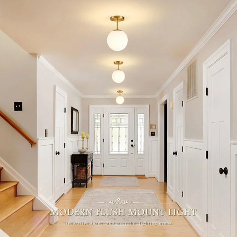 Mid Century Modern Globe Ceiling Light With Frosted Glass Ball And Totally Slick Gold Brass Finish Knockout Semi Flush Mount Fixture Comes With Dimmable E26 Warm Bulb For Hallway Stairs Or Closets, shown in a bright hallway.