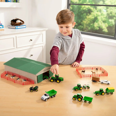 Child playing with 1 To 64 Scale Die Cast Farm Toy Playset With 70 Pieces Including Tractors Trucks Farm Animals Tools A Farm Shed And More