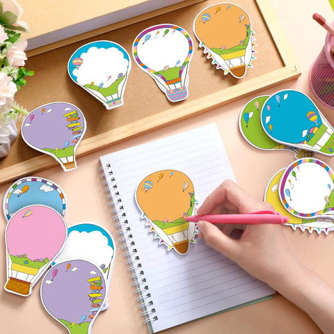 Hot Air Balloon Sticky Notes Bulk Pack, 36 Packs In 9 Styles, 1080 Sheets Total, 2.9 X 3.9 Inch Self-Stick Removable Pads shown on a desk