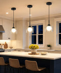 Karjearl Glass Pendant Lights Kitchen Island, 2 Pack Black Hanging Lighting above a kitchen island with a white marble top.