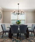 Dining room with six light black modern farmhouse chandelier and rustic vintage candle iron arms in matte black finish.