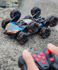 Epic 8 Wheel Hand Controlled RC Stunt Car With Gesture Sensing Remote climbing over rocks outdoors.