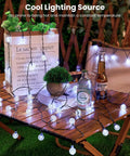2-Pack 72 Ft Solar String Lights With 120 LEDs Waterproof Outdoor Patio Lights Auto On Off 8 Modes Perfect For Garden Yard Porch Wedding Decor Pure White illuminating wooden table setup with drinks and a plant.