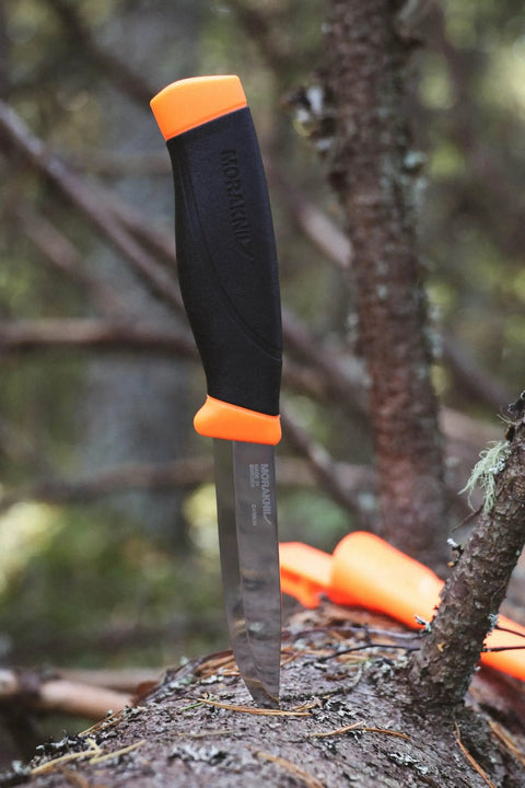 Heavy-Duty Carbon Steel Fixed-Blade Knife with Sheath, 4.1-Inch Blade, shown on tree trunk outdoors