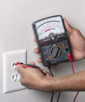 Hands using GMT 319 Multimeter Tester For Electric Pros And DIYers, RJ45 And RJ11 Ports, 7 Functions And 19 Ranges, Black at an outlet