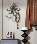 Tough As Nails 2 Pack Octopus Wall Hooks Heavy Duty Cast Iron 5 Arm Design with jewelry and coat on wall.