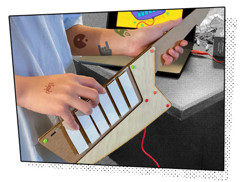 Keytar Invention Launchpad Starter Bundle For Hands On STEM Coding Learning Build Your Own Musical Instrument Kit That Lets Kids Create Code Play And Customize An Educational Instrument. child playing wooden 6-key keytar with Makey Makey