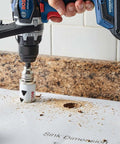 Front view of Bosch HBT225 2-1/4 in bi-metal T-slot hole saw on cordless drill cutting granite countertop.