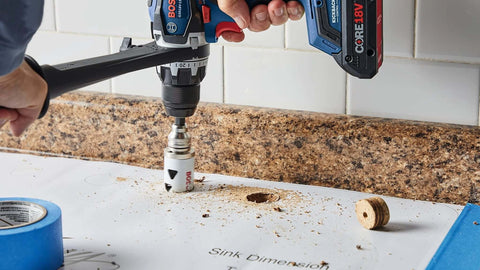 Front view of Bosch HBT225 2-1/4 in bi-metal T-slot hole saw on cordless drill cutting granite countertop.