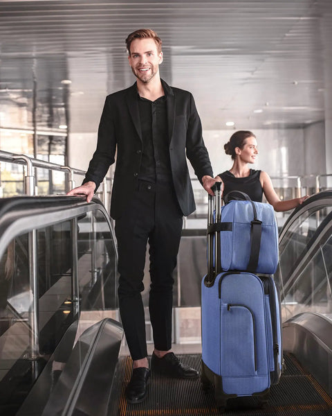 Man with Carry On Luggage For Air Travel 20 Inch Softside Spinner Suitcase With Included Duffel Bag on escalator