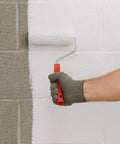 Person using a roller to apply Hardcore White Basement Sealer For Concrete And Masonry Walls Block Ten Psi Negative Hydrostatic Pressure.
