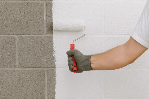 Person using a roller to apply Hardcore White Basement Sealer For Concrete And Masonry Walls Block Ten Psi Negative Hydrostatic Pressure.