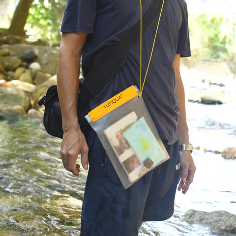 Person outdoors wearing Clear Waterproof Dry Bags Set Of Three Pouches For Phone, Camera, Maps And Documents in yellow frosted PVC.