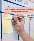 Hand writing on lined sticky notes 4x6 inch pastel color ruled post its attached to board in office setting