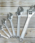 15 Inch Adjustable Wrench With 45mm Jaw Opening For Heavy Duty Garage And DIY Projects, shown with other sizes against wood