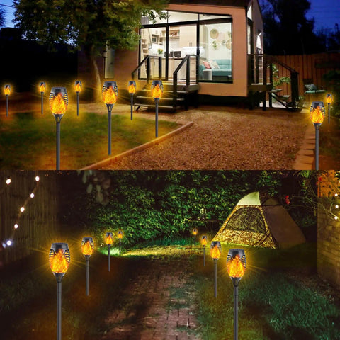12-Pack Solar Christmas Lights Outdoor With Flickering Flame Tiki Torches Waterproof Garden Lights Auto On Off Patio Decor 12 LED Solar Lamps featured along pathways at night, creating a glowing ambiance in a residential garden setting.