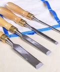 Built Tough 4 Piece Bench Chisel Set For Serious Woodworkers Carved From Top Shelf Chrome Vanadium Steel Blades laid on a tool roll.