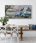 Farmhouse Canvas Wall Art Blue Vintage Pickup Truck With Blooms Over Rustic Barn Scene hung in a cozy dining area