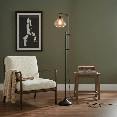 Tall Industrial LED Floor Lamp With Adjustable Head And Rustic Glass Teardrop Shade, Black Finish, beside chair and table in living room