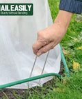 Hand installing 4 Inch Landscape Staples Pack Of 50 Galvanized Garden Stakes Anti Rust Pins For Securing Weed Barrier Fabric Artificial Turf