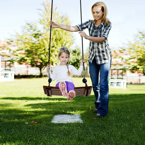 Child on Heavy Duty Wood Swing Seat Carbonized Outdoor Swing For Adults And Kids in sunny park, mom adjusting 6.6 ft rope.