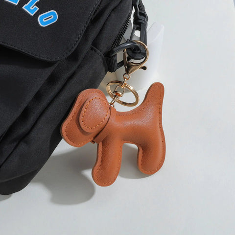 Premium Faux Leather Dog Bag Charm With Sturdy Metal Keyring attached to a black backpack, featuring a cute brown dog design.