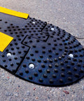 Close-up of speed bump anchored on asphalt using Driveway Expansion Screws For Speed Bump Installation And Concrete Asphalt Anchoring.