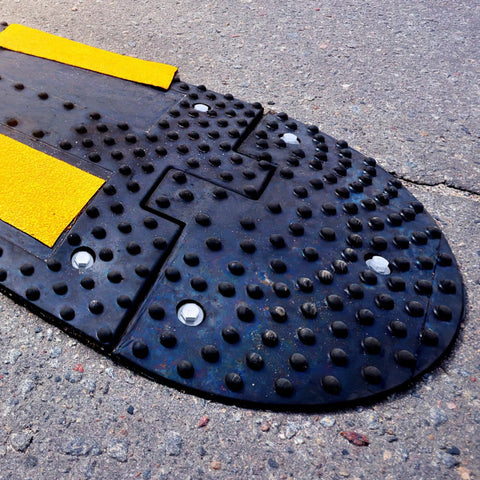 Close-up of speed bump anchored on asphalt using Driveway Expansion Screws For Speed Bump Installation And Concrete Asphalt Anchoring.