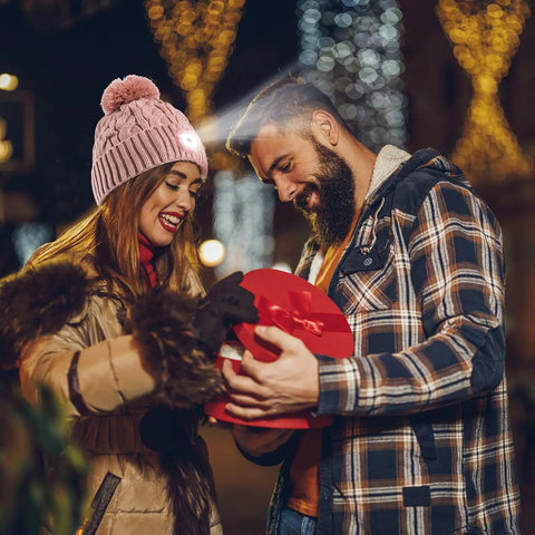 Couple exchanging gift, woman wearing Unisex Winter Beanie With Built In LED Light Headlamp Hat USB Rechargeable For Men And Women.