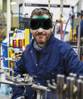 Kick Ass Flip Up Welding Goggles Heavy Duty Safety Glasses Rugged 2 Pack Welder Shades worn by a man in an industrial setting.