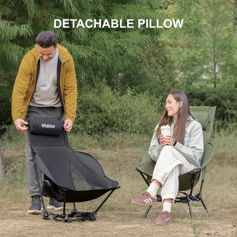 Two people outdoors with a Compact High Back Camp Chair With Dual Sitting Modes Pillow Arm Pads And Side Pockets For Motorcycle RV Festival And Travel Lightweight Portable Green, featuring detachable pillow.