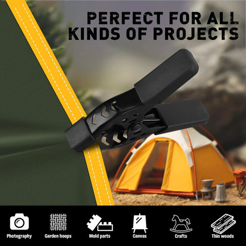 Close-up of Heavy Duty 6 Piece 4 Inch Spring Clamp on tarp with tent backdrop, outdoor use, nickel plated steel construction.