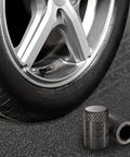 Heavy Duty 4 Pack Tire Valve Stem Caps For Tesla Cybertruck 2024 Through 2026 with tire and aluminum caps on pavement.