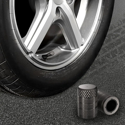 Heavy Duty 4 Pack Tire Valve Stem Caps For Tesla Cybertruck 2024 Through 2026 with tire and aluminum caps on pavement.