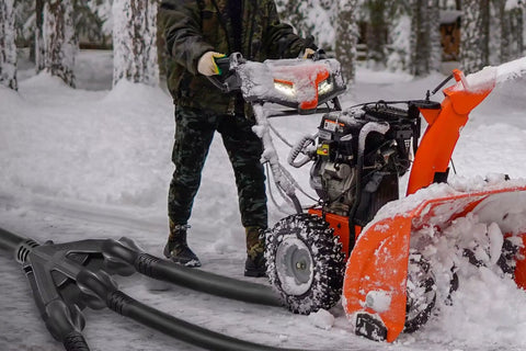 150 Ft 12 Gauge Heavy Duty Black Extension Cord With 3 Outlets powering snowblower in snowy yard