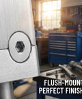 Close-up of flat head hex socket screw M8x60mm stainless steel mounted flush in metal surface, workshop background